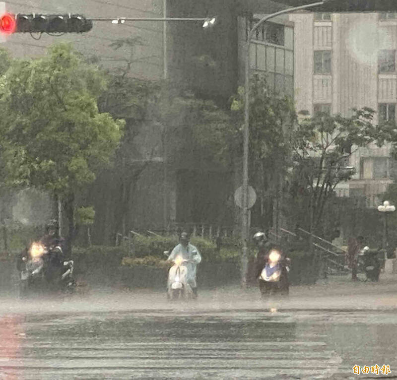 中颱凱米颱風眼出海後，台中市區持續降雨，圖為上班騎士在台灣大道停等紅燈淋雨情形。（記者黃旭磊攝）