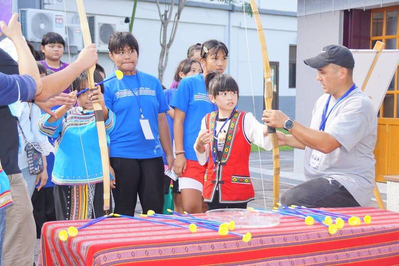 南山國小教師卓孟涵於成果展協同各校學生體驗射箭遊戲活動。（圖由教育部提供）