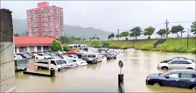 軍功橋下停車場因貓羅溪水暴漲溢出，車子泡在水中。（民眾提供）