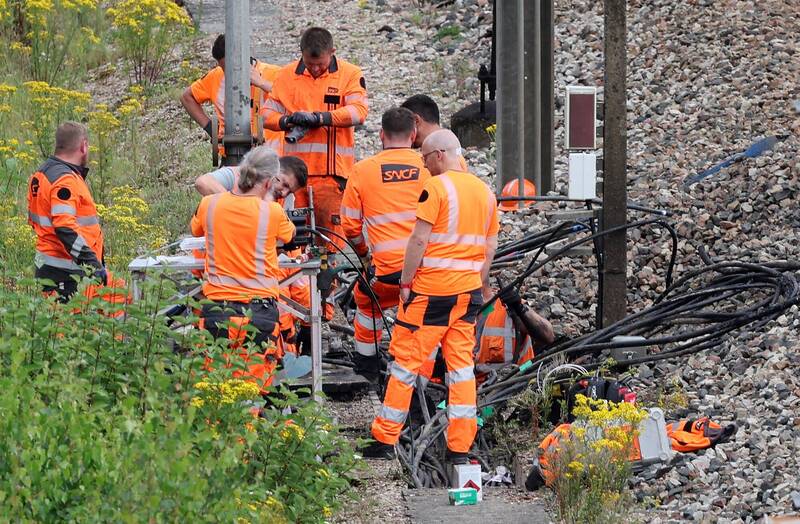 法國高速列車（TGV）鐵路網遭人縱火破壞，工作人員搶修中。（法新社）