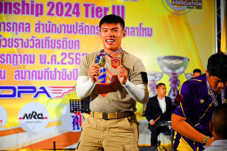 
New Taipei City police officer Wang Kuan-wen poses with a medal he won at an International Defensive Pistol Association competition held in Hua Hin, Thailand, from July 12 to 13.
Photo courtesy of the New Taipei City Police Department