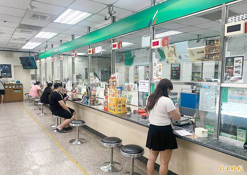 
People stand by service windows in a post office in an undated photograph.
Photo: Taipei Times file