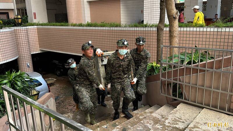 大型冷藏櫃被沖入地下室，國軍弟兄今持續協助日安大樓地下室雜物的清除工作。（記者許麗娟攝）