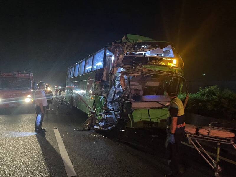 車禍造成遊覽車車頭幾乎被削掉一半，且無法開啟車門，消防員只好架起梯子從遊覽車窗爬入車內救援。（民眾提供）