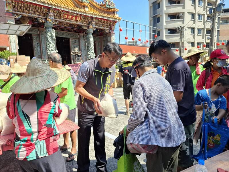 金山區長劉昌松（中）和新生活促進會志工一起致贈生活物資給家戶。（新北市社會局提供）