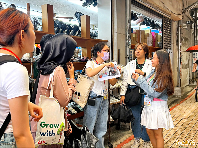 青年導覽志工帶領民眾和國際友人深入屏東市中央市場商圈，了解在地故事。
（記者羅欣貞攝）