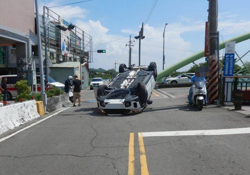 台中一名黃姓男子，今天下午1點多駕車行經霧峰乾溪東路與四德路口時，不慎自撞路邊護欄後四輪朝天翻覆。（記者陳建志翻攝）