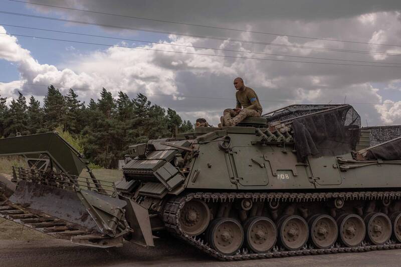 烏克蘭軍人13日在靠近俄羅斯邊境的蘇梅地區操作一輛裝甲軍車。（法新社）