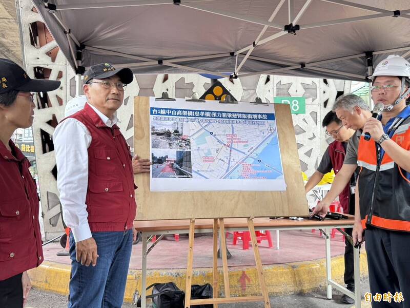 新北市養護工程處長鄭立輝（右拿麥克風）向市長侯友宜（左）報告今晨交通一事。（記者羅國嘉攝）