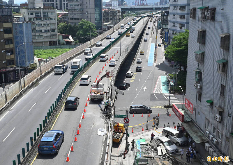 新北市三重區通往忠孝橋的中山高架道上拖板車所載鋼梁翻覆，護欄撞毀，往台北方向開放單線通車。（記者王藝菘攝）