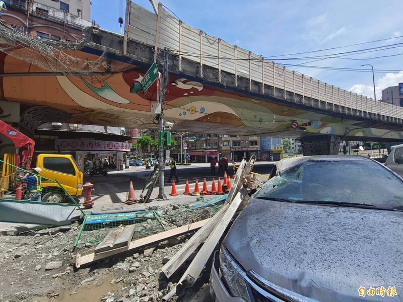 新北市三重區中山高架道上聯結車所載鋼梁翻覆，破損護欄砸到下方車輛。（記者王藝菘攝）