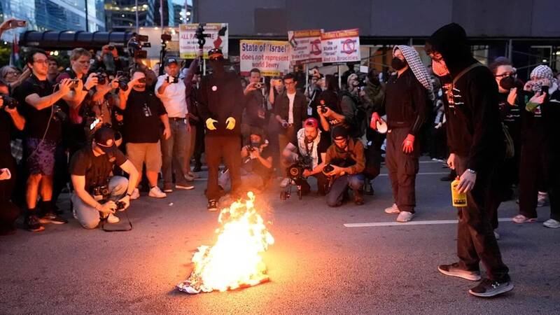 芝加哥民主黨大會爆發抗議，示威者於以色列領事館附近焚燒美國國旗。（美聯社）