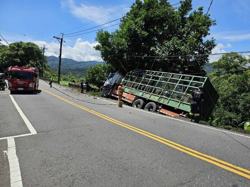 大貨車失控撞上電桿後滑落邊坡，導致整輛車傾斜，所幸駕駛僅受到輕傷。（記者陸運鋒翻攝）