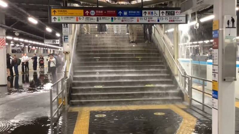 日本東京昨晚下起「游擊式暴雨」，品川車站雖然沒有出現淹水的情況，但室外月台樓梯因大雨變成「瀑布」，讓進出月台的乘客因此被淋成落湯雞。（圖擷取自@yui_kun 社群平台「X」）