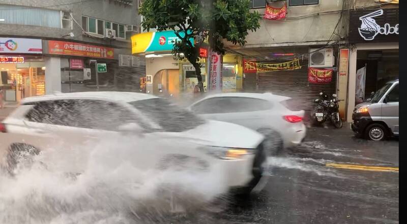 新北下大雨，永和街道積水，車輛行經激起水花。（擷取自「我是永和人」臉書）