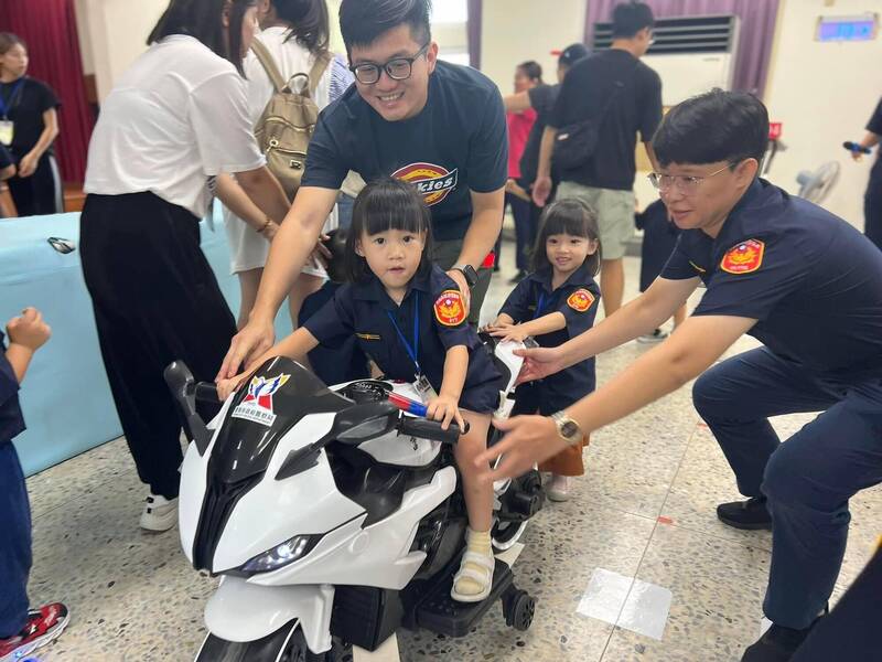 警察子女穿上小警察制服騎小重機，在南市警五分局內模擬車道體驗安全駕駛。（圖：警方提供）