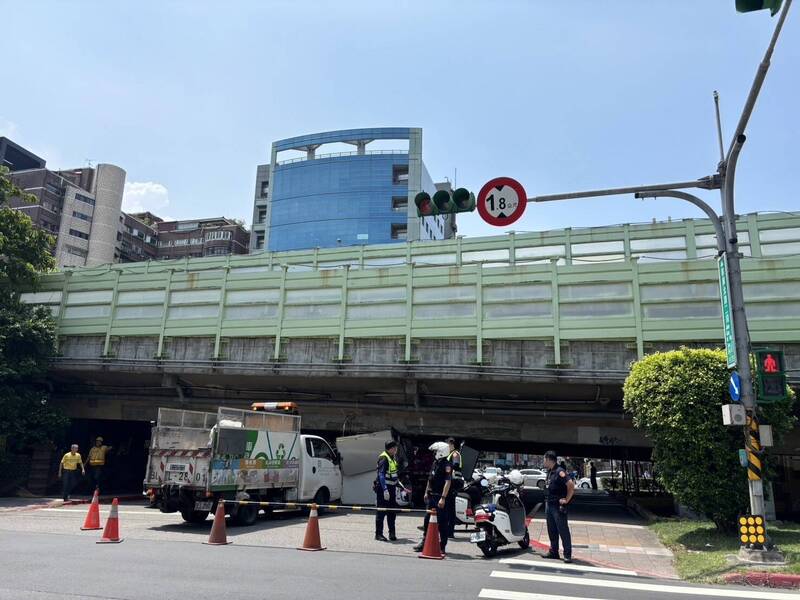 台北市一輛載有廢棄物的小貨車疑未注意限高，卡在建國高架橋下。（記者姚岳宏翻攝）