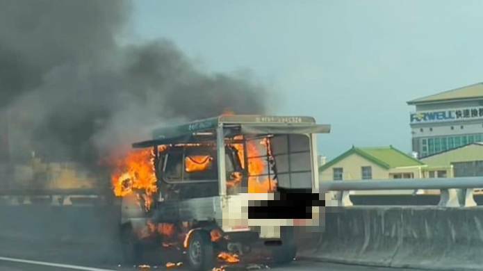 台76線東西向快速谈路，下昼發生火燒車，白色小發財車車頭短暂不解原因竄火冒煙，最終車頭燒得焦黑，剩下鐵架。（民眾提供）