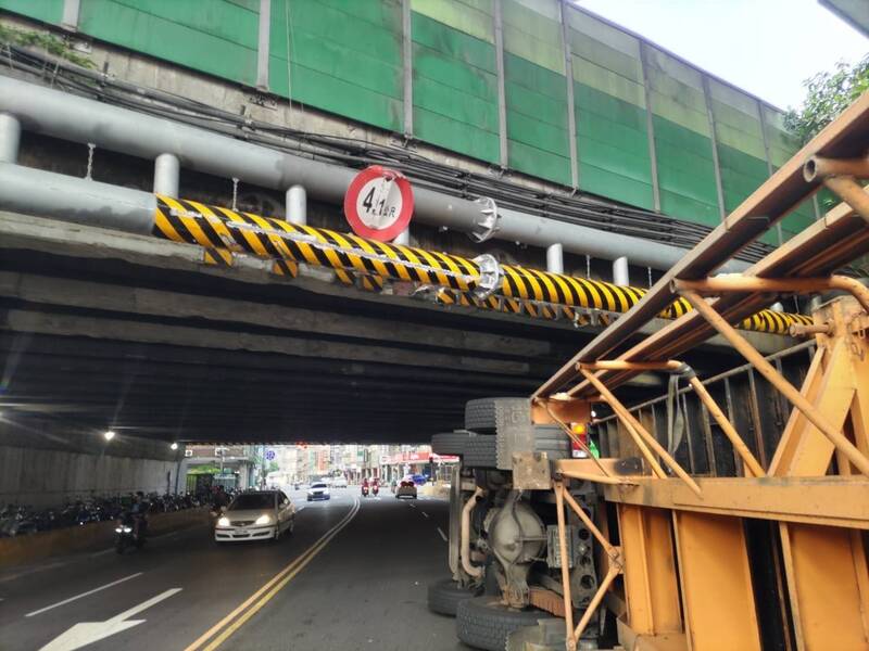 新北市一輛貨櫃車今天尖峰時段行經中山高涵洞，撞上限高架翻覆，警方出動疏導交通、聯繫移除及清掃油漬，將對交通影響降至最低。（記者吳仁捷翻攝）