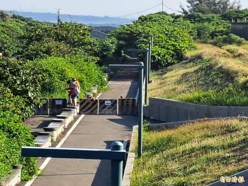 新竹市十七公里自行車道港南公園路段封閉卻指示不明挨批，且導致有車友只能冒險跨越護欄搬腳踏車，除險象環生也因指引動線不明確而抱怨失去騎車興緻。（記者洪美秀攝）