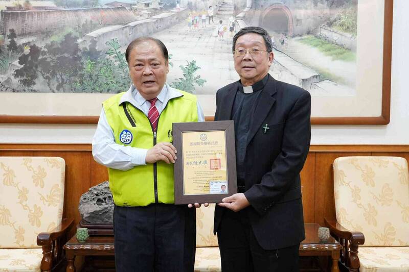 澎湖縣長陳光復（左）頒發榮譽縣民證給啟明長老教會牧師劉堅望（右）。（圖由澎湖縣政府提供）