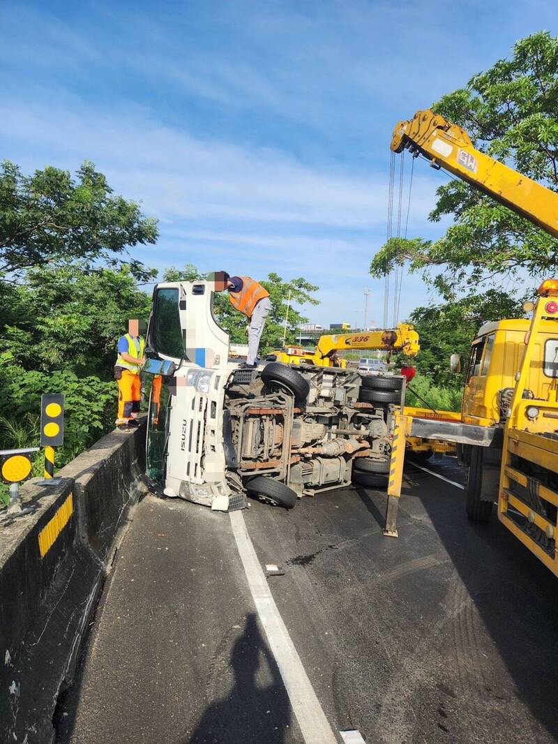 小貨車行經國1高科交流道北向入口環道失控側翻，車上貨物包裹掉落路面，所幸無人受傷。（民眾提供）