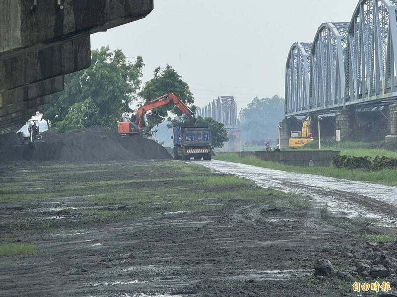 大樹舊鐵橋溼地公園遭到土砂覆蓋，水利局派工出動怪手清除土砂。（記者陳文嬋攝）

