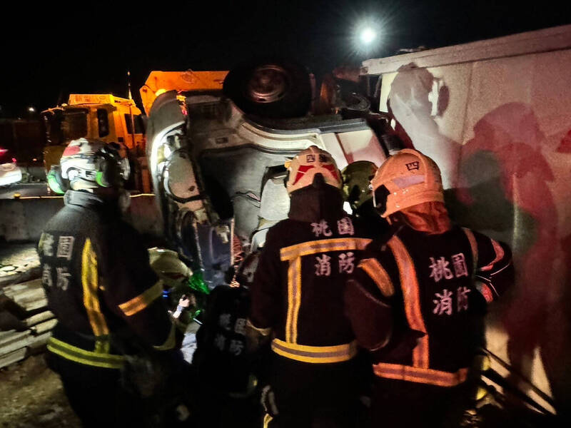 國3大溪路段貨櫃車疑酒駕失控衝出邊坡掉落平面道路，駕駛受困，警、消全力救援。（記者李容萍翻攝）