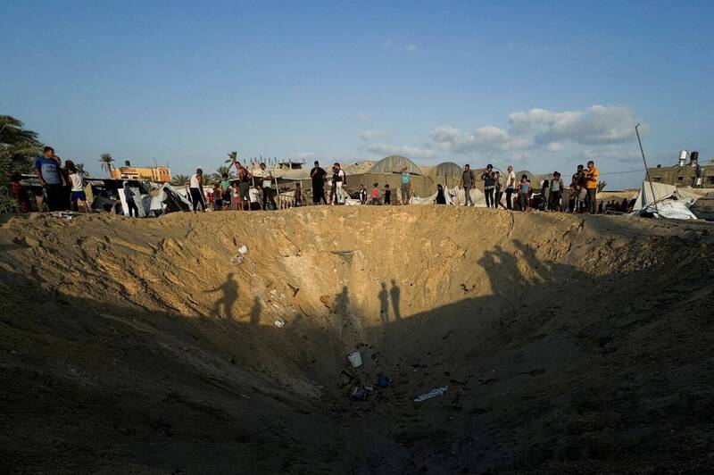 以色列於加薩（GAZA）當地時間週二凌晨襲擊加薩走廊南部的穆瓦西地區（Al-Mawasi），在地面上轟炸出數個大坑。（路透）