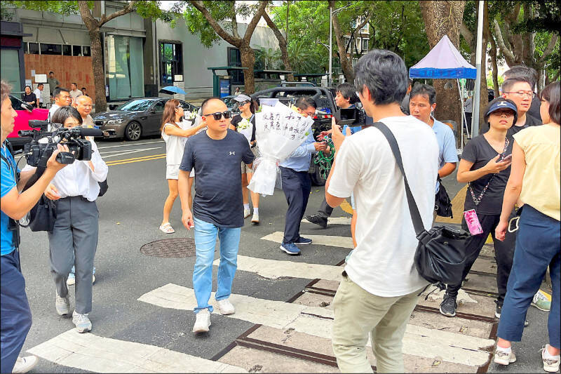 民眾手持的追悼花束上寫有「反暴力」、「中日友好」等字樣。（路透）