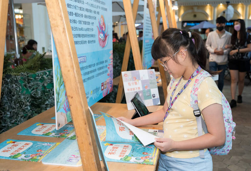 環教繪本板橋大遠百展出，現場擺設實體書與有聲電子書供民眾閱覽。（圖由新北市環保局提供）