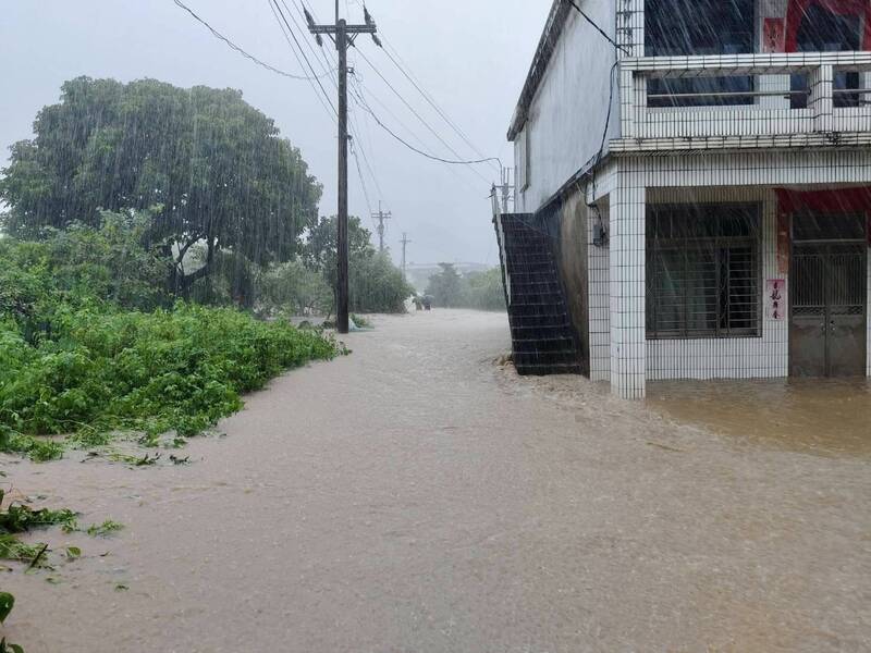 李姓夫婦最後身影照，2人撐著黑色雨傘受困暴漲溪水中，（鄰居提供，記者林嘉東翻攝）