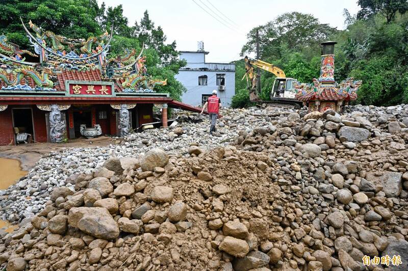 受到山陀兒颱風外圍環流影響，新北市金山區降下大雨，多處出現淹水情形。金山區長興宮前發生土石流，一旁民宅也遭土石掩蓋。（記者陳志曲攝）