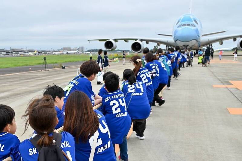 成田機場舉行飛機拔河比賽，小學生與家長賣力拉動最大客機空巴A380。（擷取自traicy官網）