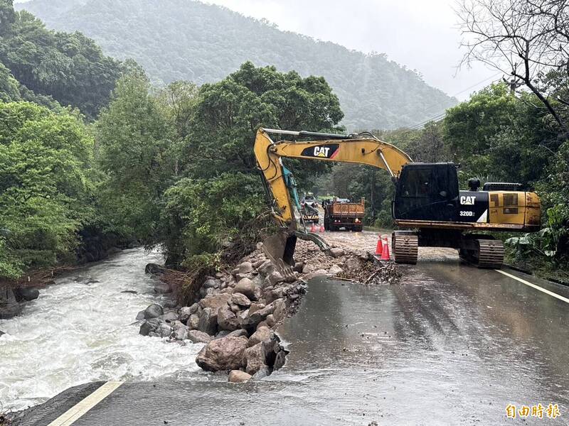 八連溪旁道路被削一半，市府與公所派機具正積極搶修。（記者羅國嘉攝）