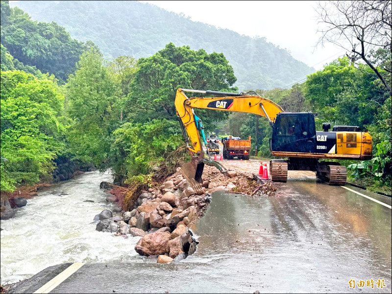 三芝區八連溪旁道路被削一半，出動機具進行搶修。
（記者羅國嘉攝）