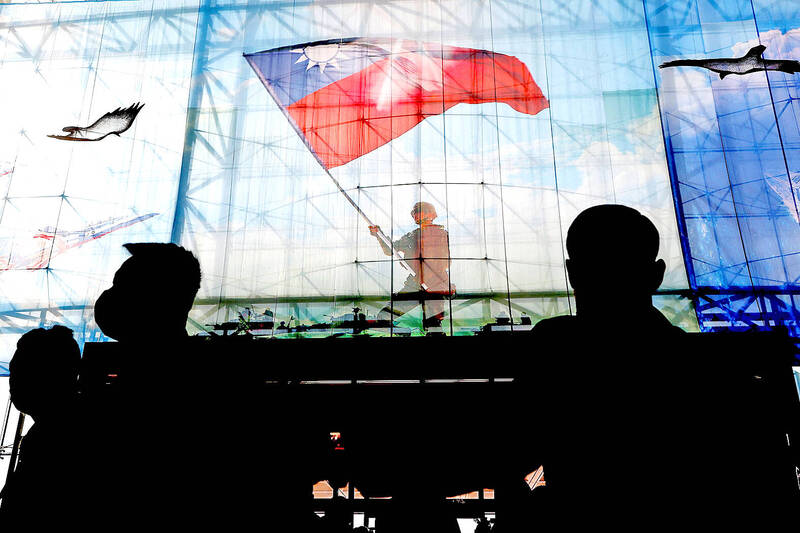 People are silhouetted against an image displayed at the Ministry of National Defense in Taipei on Dec. 26, 2022.
Photo: Ann Wang, Reuters