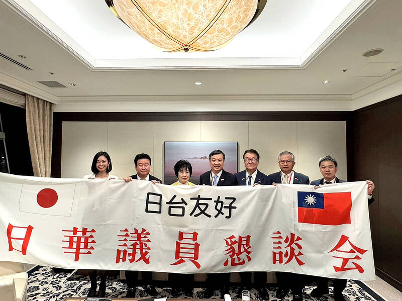 A delegation led by Japanese Senator Akiko Santo, third from left, and Representative to Japan Lee Yi-yang, center, hold a banner with a message of friendship between Taiwan and Japan in Tokyo yesterday.
Photo: CNA