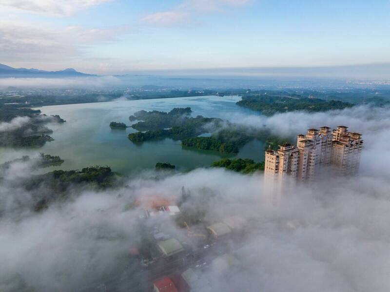 嘉義近日受東北季風影響，清晨出現低空雲海，嘉南第一景大樓旁雲霧繚繞，網友稱讚宛如仙境。（黃源明提供）