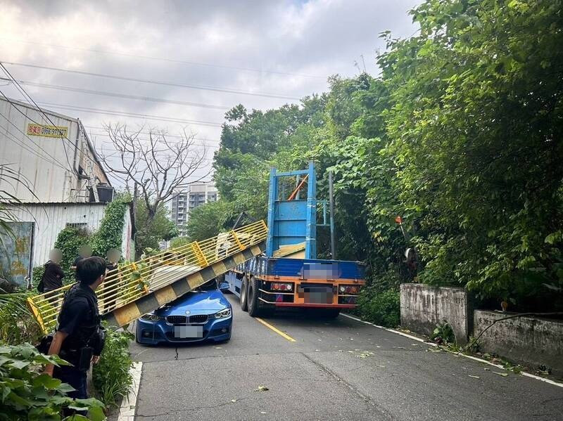 貨車後斗貨物太高，將限高門架撞落，砸中路過轎車。（記者徐聖倫翻攝）