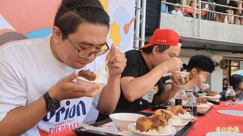 參賽者拚命把飯和大塊爌肉往嘴裡塞，吃得津津有味。（記者張聰秋攝）