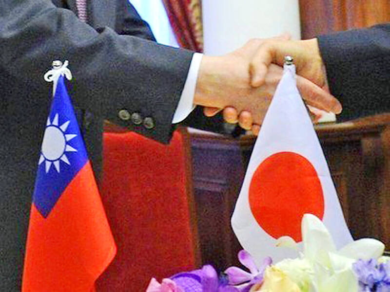 
People shake hands in front of the national flags of Taiwan and Japan in an undated photograph.
Photo: CNA