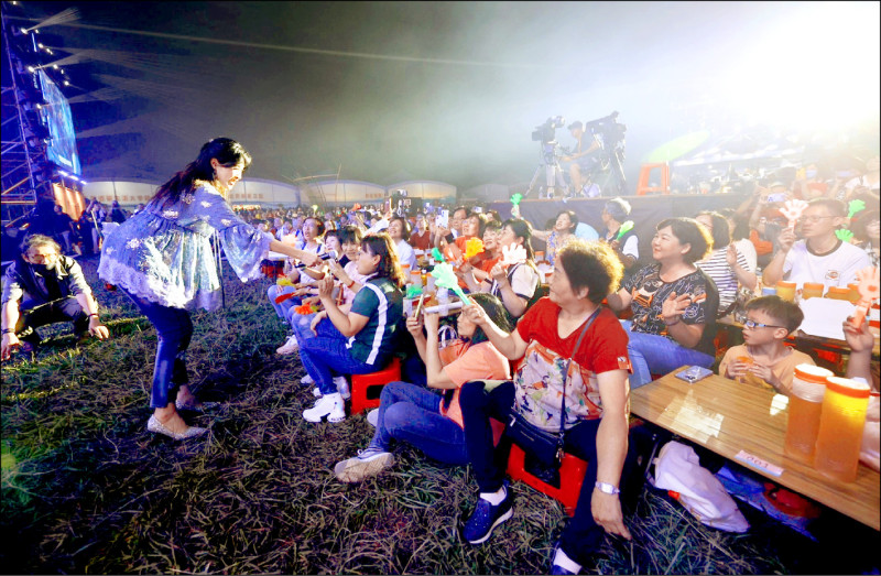 昨晚世界茶業博覽會「民歌之夜」現場，歌手方季惟（左）到台下與粉絲握手互動。（南投縣府提供）