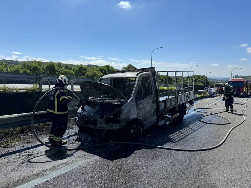 國1高速公路今天上午11點13分發生火燒車，1輛小貨車失火陷入火海，消防人員滅火後，貨車車頭幾乎全毀。（圖，國道公路警察局提供）