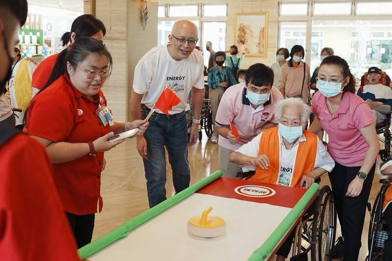 102歲許阿嬤參加銀髮運動會，在桌上推壺時神情專注。（清福長照集團提供）