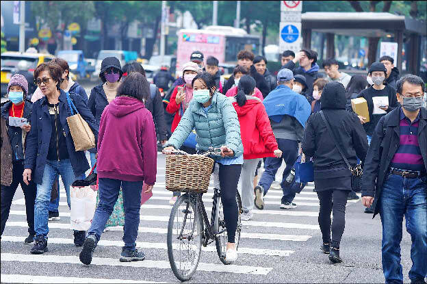 People cross a street in Taipei’s Zhongshan District on Jan. 10.
Photo: CNA