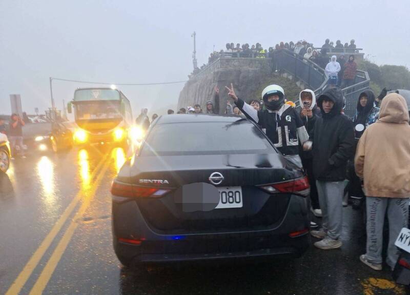 黑色轎車違規停在武嶺亭階梯前的台14甲線大馬路上，車上人員就消失不見，嚴重影響交通。（民眾提供）