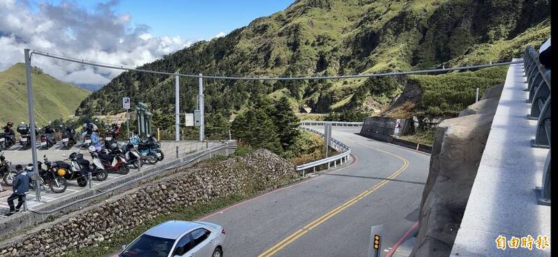 合歡山武嶺亭與對面的武嶺停車場，最近多了一根電線橫空跨越台14甲線。（記者佟振國攝）