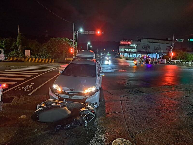 王姓男子駕車與何姓機車女騎士發生碰撞，何女人噴飛手腳擦挫傷，機車卡在轎車前保桿下。（記者林嘉東翻攝）