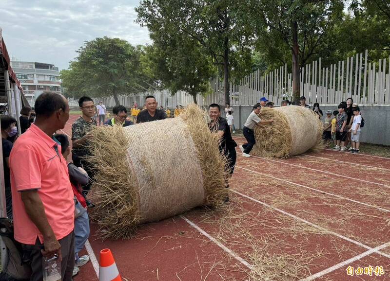 台中烏日區農會今天舉行稻米產業文化節，現場安排推稻草捲競賽，參加的隊伍都賣力推動稻草捲，現場趣味橫生。（記者陳建志攝）